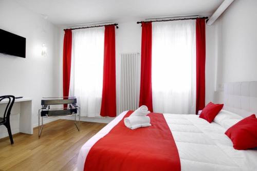 a bedroom with a red and white bed with red curtains at Fenix La Bohéme in Venice