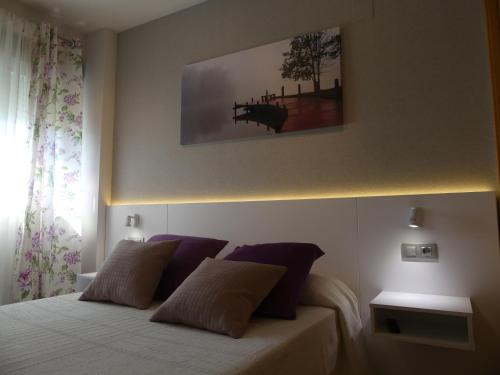 1 dormitorio con 1 cama con almohadas moradas en Apartamento Don Pablo by DLV, en Villajoyosa