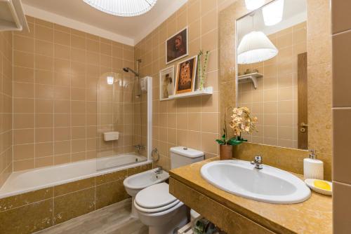 a bathroom with a sink and a toilet and a tub at Varanda do Castelo - Charming Apartment in a Historical Town in Silves