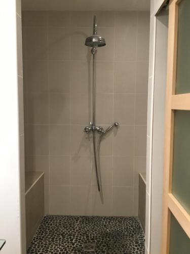 La salle de bains est pourvue d'une douche et de carrelage. dans l'établissement Chambres d'hôte Ô Bois Plage, à Gujan-Mestras