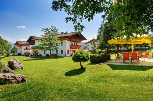 una casa con mesa y sillas en un patio en Sonnberg Ferienanlage, en Flachau