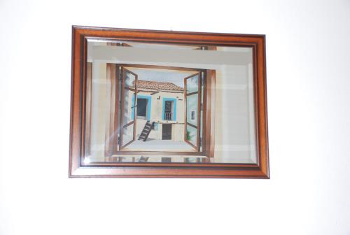 a mirror in a wooden frame on a wall at Hotel Belvedere Tonara in Tonara