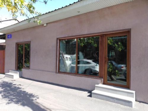 a building with glass windows with a car in the reflection at REST Guest House in Yerevan