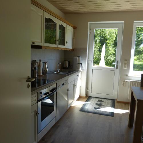 a kitchen with white cabinets and a white door at Zur Amsel in Damnatz