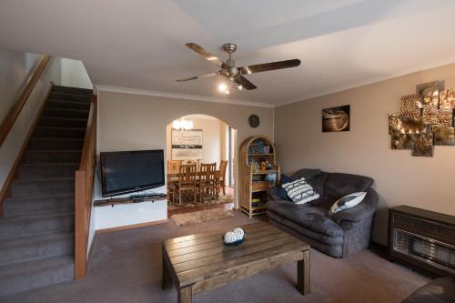 a living room with a couch and a tv at Glenelg North " Home Away From Home" in Adelaide