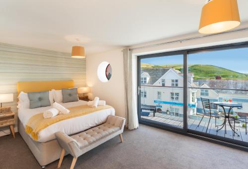 a bedroom with a bed and a large window at 11 Woolacombe West - Luxury Apartment at Byron Woolacombe, only 4 minute walk to Woolacombe Beach! in Woolacombe