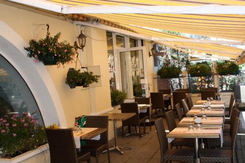 サン・ミッシェル・ド・モリエンヌにあるSavoy Hotel & Restaurantの木製のテーブルと椅子、植物のあるレストラン