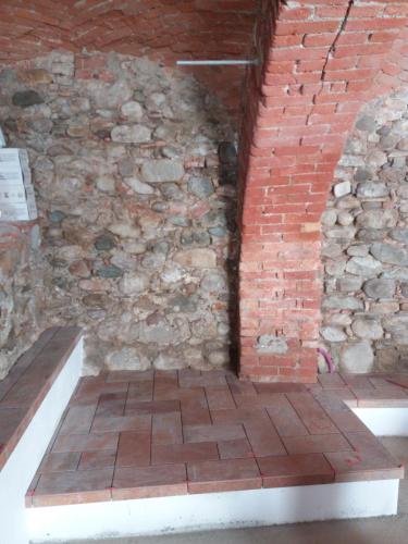 a room with a brick wall and a bench at Affittacamere Il Borgo in Ceva