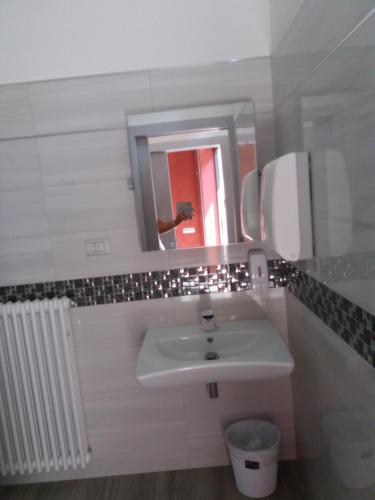 a white bathroom with a sink and a mirror at Affittacamere Il Borgo in Ceva