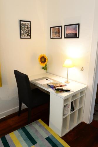 a white desk with a lamp and a chair at Lilis kleines Hotel in Münster