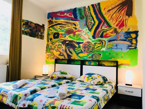 una camera con due letti e un dipinto sul muro di Green House a Kvareli