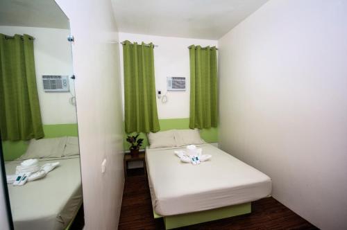 a small room with two beds and a mirror at Sulit Budget Hotel near Dgte Airport Citimall in Dumaguete