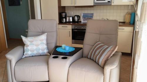a living room with two chairs and a table at Strandburg, das smarte Penthouse in ÜckeRitz mit PKW Stellplatz! in Ueckeritz