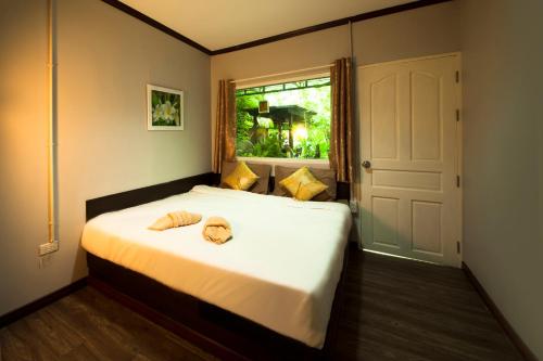 a bedroom with a bed with two hats on it at Hatthatara Resort in Samut Songkhram