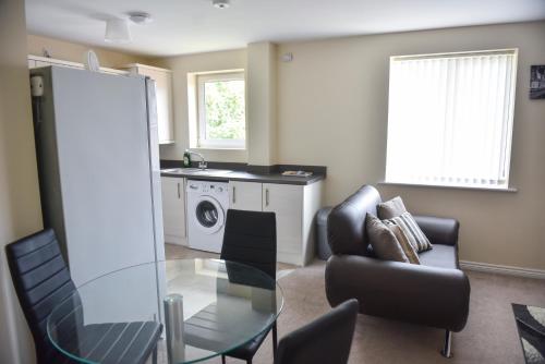 a living room with a glass table and chairs at Smartrips Apartments in Coventry
