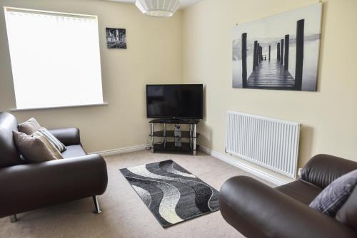 a living room with a tv and a couch at Smartrips Apartments in Coventry