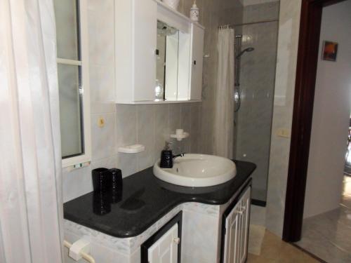 a bathroom with a white sink and a shower at Villetta Girasole in Lampedusa