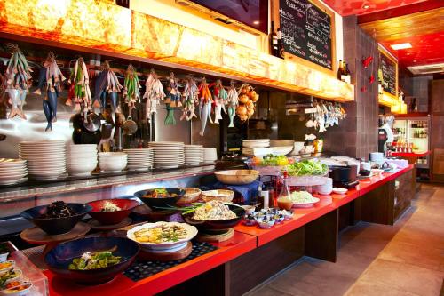 a buffet line with bowls and plates of food at Hotel Resol Kyoto Kawaramachi Sanjo in Kyoto