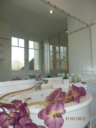 a bathroom with three sinks and a large mirror at Hotel & Restaurant Karpfen in Illmensee