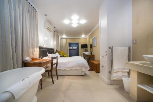 a hotel room with a bed and a bathroom at Batavia Boutique Hotel in Stellenbosch