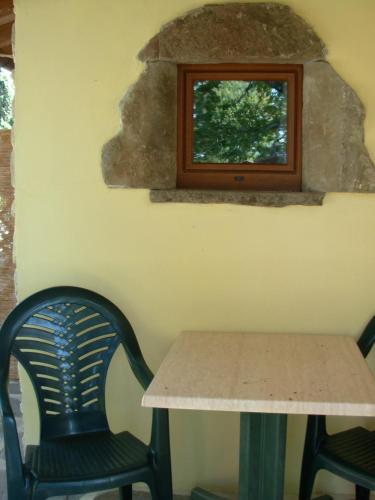 a table and two chairs next to a window at Agriturismo Santa Rosa in Subbiano
