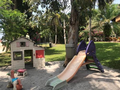 a playground with a slide and a play house at Hotel Coucoue Lodge in Assinie