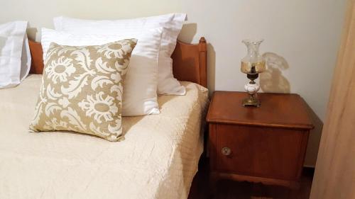 - un lit avec un oreiller et une table de chevet avec une lampe dans l'établissement BEST HOUSE, Attiki Metro, Athens, à Athènes