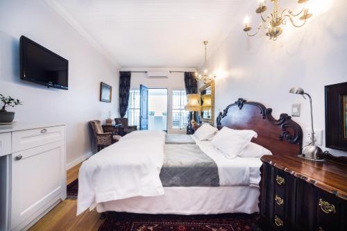a bedroom with two beds and a television at Batavia Boutique Hotel in Stellenbosch