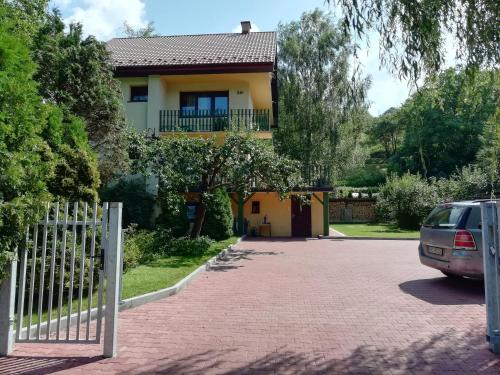 a house with a car parked in front of a driveway at Willa Mirabelka in Piwniczna