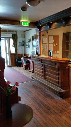 un vestíbulo con bar, mesa y sillas en Kirkenes Hotell en Kirkenes