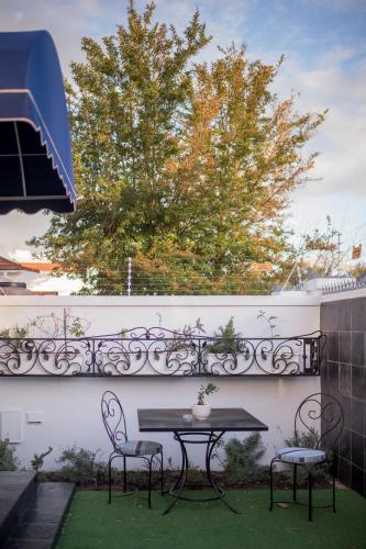 a patio with a table and two chairs and a tree at Batavia Boutique Hotel in Stellenbosch
