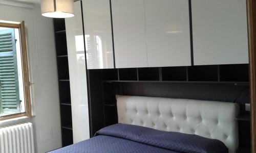 Casa delle Rose في Roa Marenca: غرفة نوم مع سرير مع اللوح الأمامي الأبيض ونافذة