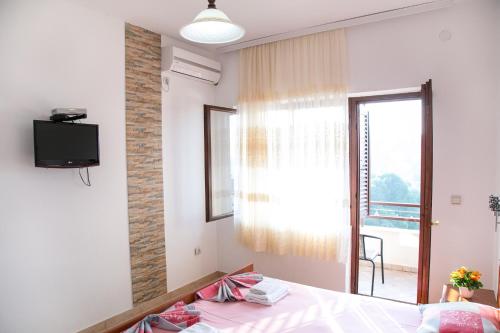 1 dormitorio con 1 cama, TV y ventana en Apartments Aga, en Ulcinj