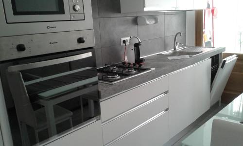 Casa delle Rose في Roa Marenca: مطبخ مع موقد الفرن العلوي بجوار الحوض