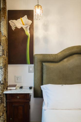 a bedroom with a bed and a picture of a flower at Batavia Boutique Hotel in Stellenbosch