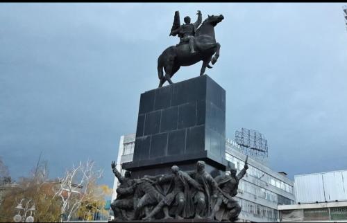 a statue of a man on a horse in front of a building at Apartments & Dream Rooms in Niš
