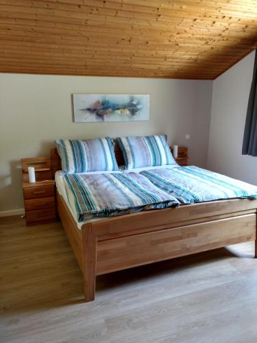 a bed in a bedroom with a wooden ceiling at Gailtal Panorama in Kötschach