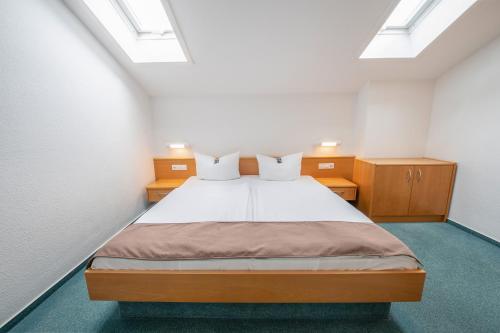 a bedroom with a bed with white sheets and skylights at Rügener Ferienhäuser am Hochufer in Göhren