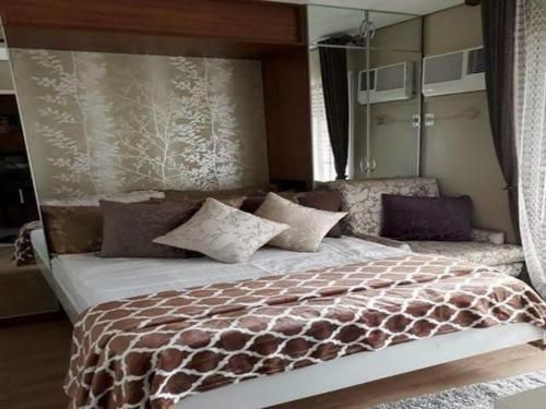 a bedroom with a large bed with a brown and white comforter at Sorrel Residences Condo Apartment by Fe in Manila