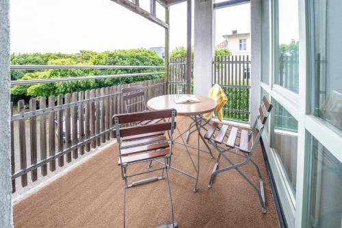a balcony with a table and two chairs at Rügener Ferienhäuser am Hochufer in Göhren
