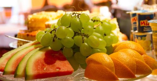 Un racimo de uvas verdes y naranjas sobre una mesa en Hotel Kolorowa, en Karpacz