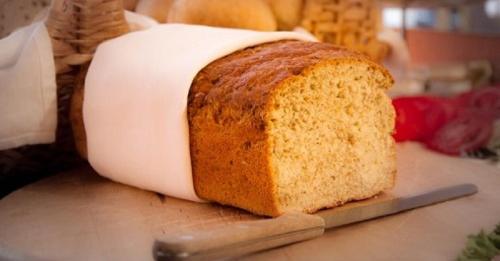 una hogaza de pan sentada en un mostrador con un cuchillo en Hotel Kolorowa, en Karpacz