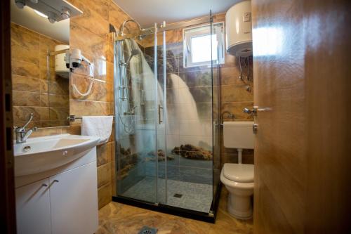 a bathroom with a shower and a toilet and a sink at Motel Aura in Mostar