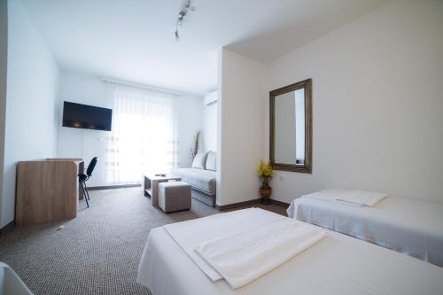 a hotel room with two beds and a mirror at Motel Aura in Mostar