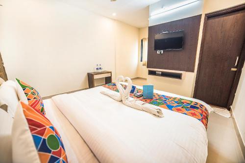 a hotel room with a bed with a pair of shoes on it at Hotel Suraj Palace in Udaipur