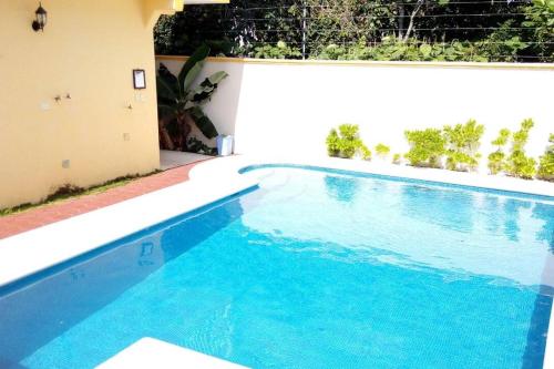 a swimming pool with blue water in a house at Casa Coral Cozumel in Cozumel