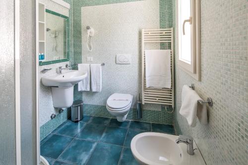 a bathroom with a white sink and a toilet at Acqua & Sale Hotel in Cervia