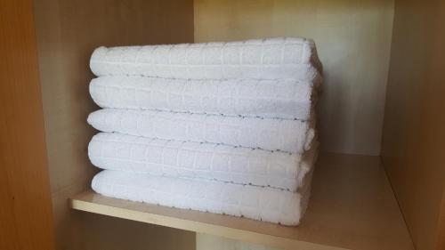 una pila de toallas blancas sentadas en un estante en Barceló Cornellà en Cornellá de Llobregat