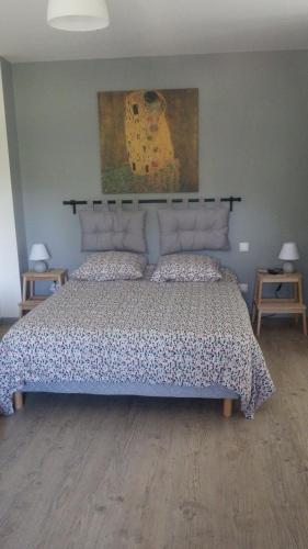 een slaapkamer met een groot bed met een bloemsprei bij La maison de l'écluse in Trèbes