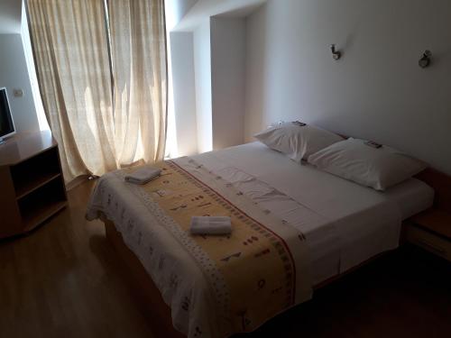 Apartment Ivana في فيغاني: غرفة نوم بسرير ابيض مع نافذة